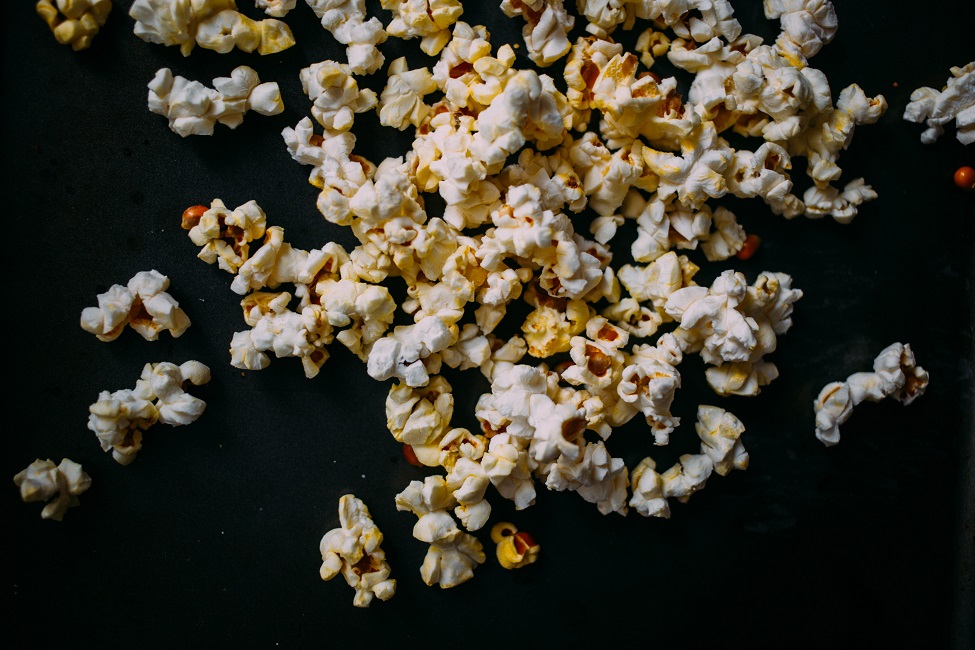 Verstreutes Popcorn auf schwarzem Untergrund.