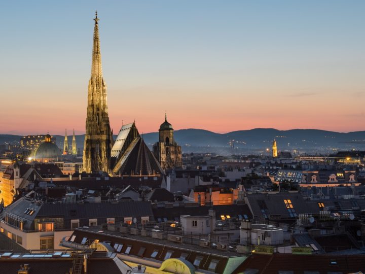 Blick von oben auf die Stadtsilhouette Wiens nach Sonnenuntergang.